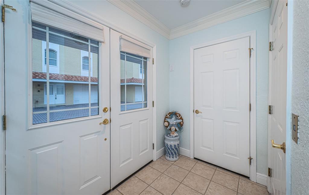 An entryway features a tiled floor, double glass-paneled front doors, and a white interior door — 11595 GULF BOULEVARD UNIT 6, TREASURE ISLAND, FL