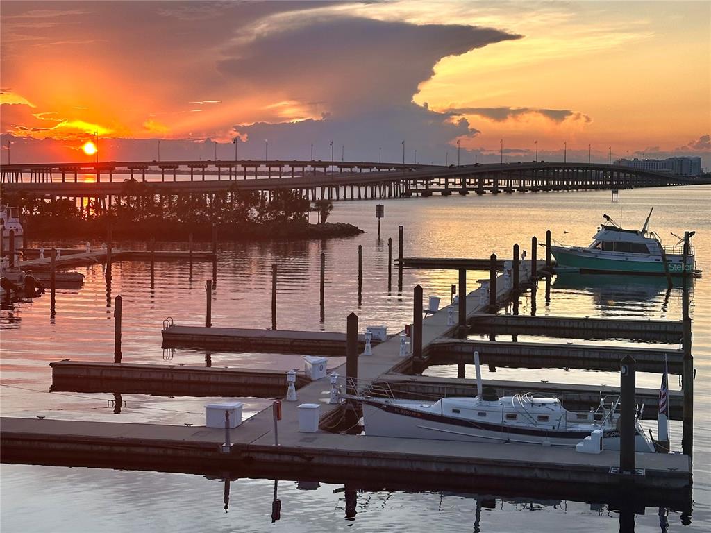 A marina with boats docked at sunset under a bridge and a cloudy sky — 6533 JACK STREET, PUNTA GORDA, FL