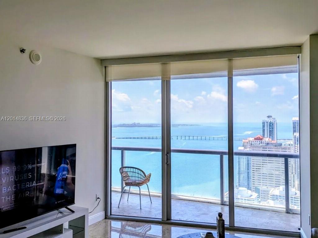 A living room features a television and a balcony with a view of the ocean — 495 Brickell Ave # 4809, Miami FL 33131, MIAMI, FL