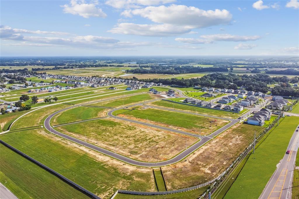 An aerial view shows a newly developed residential subdivision with paved roads and vacant lots — 12290 STIRRUP DRIVE, DADE CITY, FL