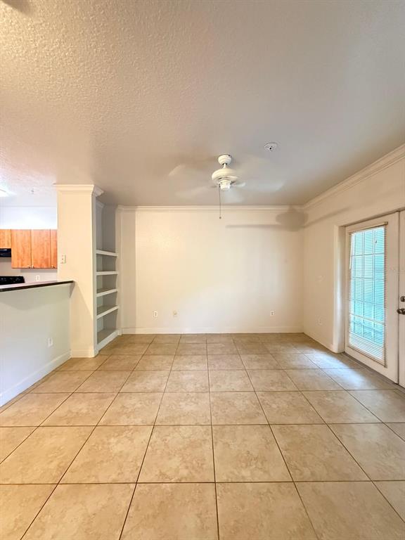 An empty dining area features tile flooring, a ceiling fan, and built-in wall shelving — 202 E SOUTH STREET UNIT 2038, ORLANDO, FL