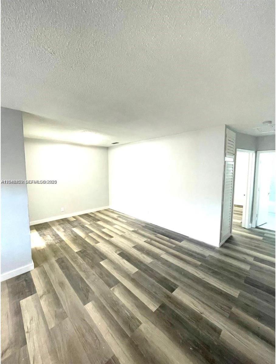 An empty room features light gray walls and wood-look plank flooring — 1431 S 14th Ave # 208, Hollywood FL 33020, HOLLYWOOD, FL