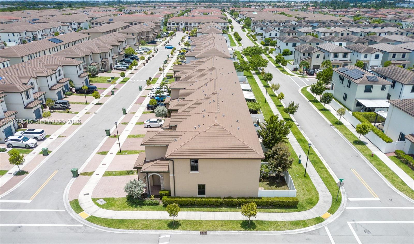 An aerial view shows a row of attached townhouses with brown tile roofs and driveways — 11064 W 33rd Way, Hialeah FL 33018, HIALEAH, FL