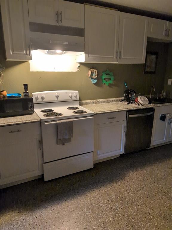 A kitchen features white cabinets, a white electric stove, a dishwasher, and speckled flooring — 5610 WILSON ROAD, SANFORD, FL