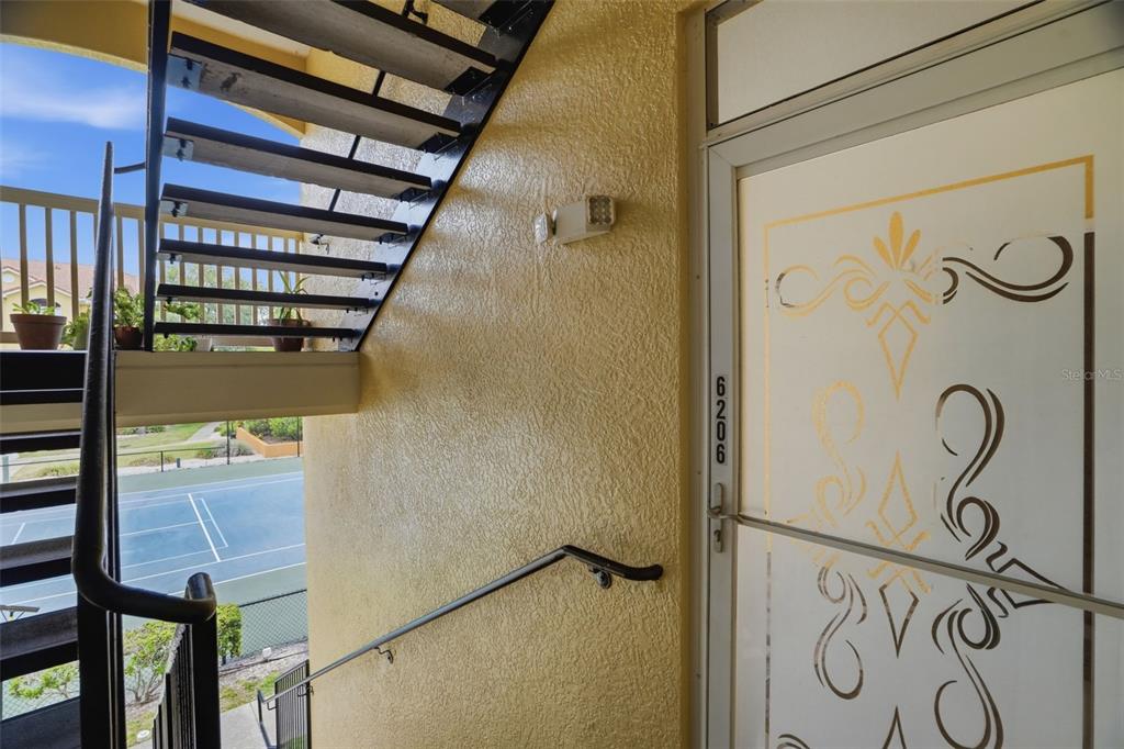 An exterior staircase leads to a doorway with a decorative glass insert and unit number — 10764 70TH AVENUE UNIT 6206, SEMINOLE, FL