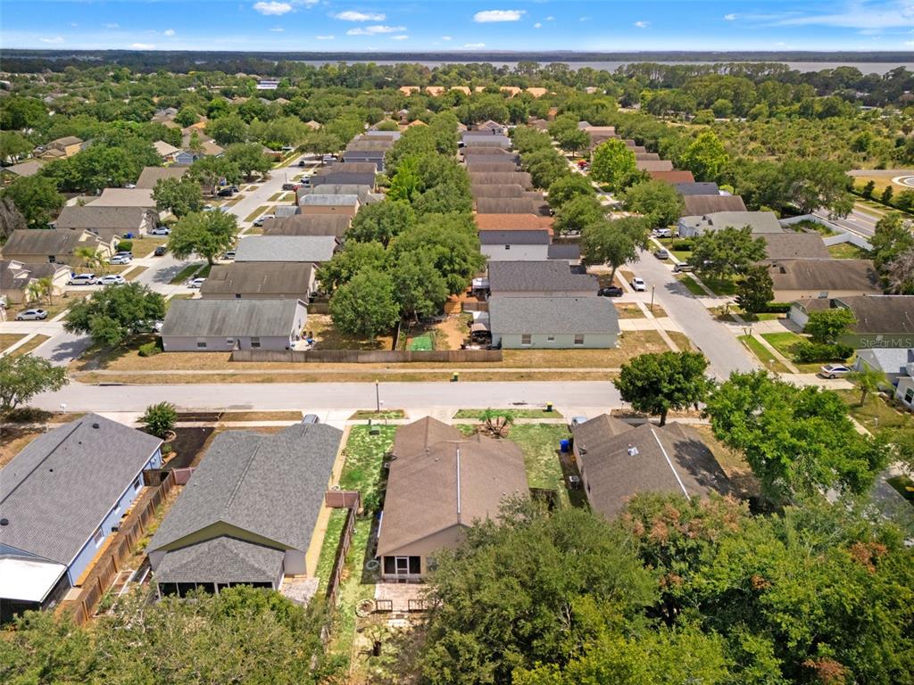 An aerial view shows a suburban neighborhood with multiple single-family homes and tree-lined streets — 2318 BARONS COURT, TAVARES, FL