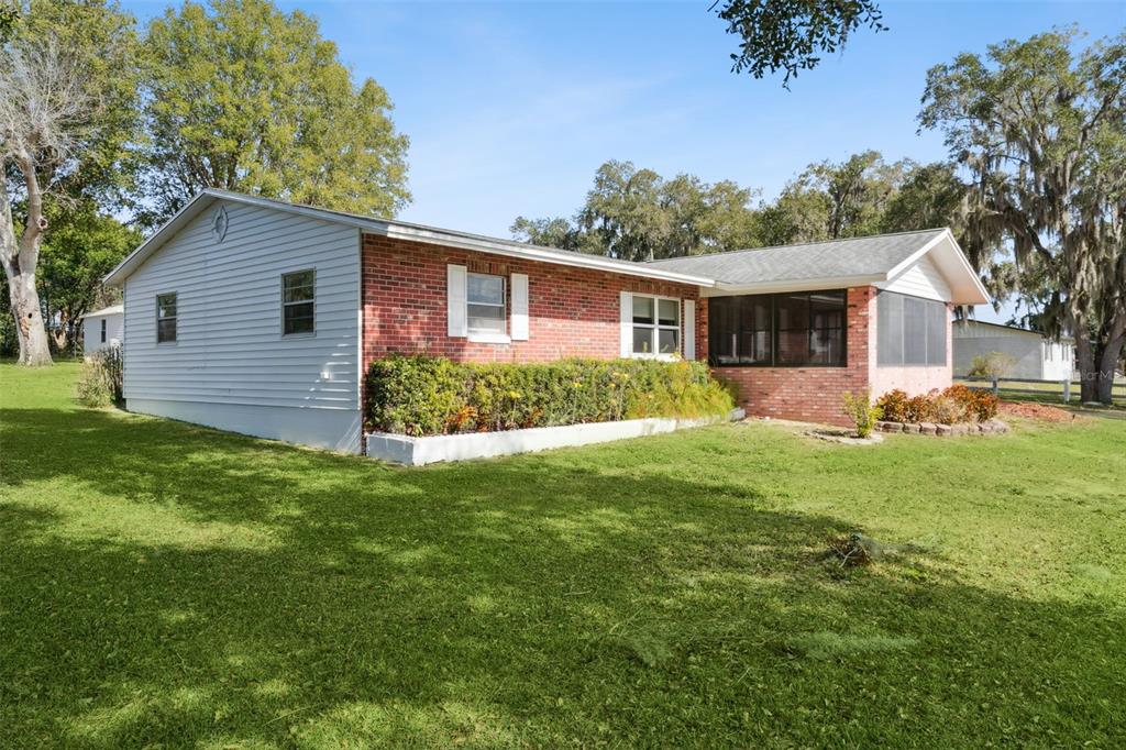 A single-story house with a brick and white siding exterior and a screened-in porch — 17530 COUNTY ROAD 455, MONTVERDE, FL