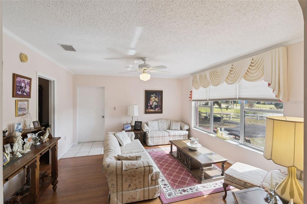 A living room features floral sofas, a wooden coffee table, and large windows with valances — 17530 COUNTY ROAD 455, MONTVERDE, FL