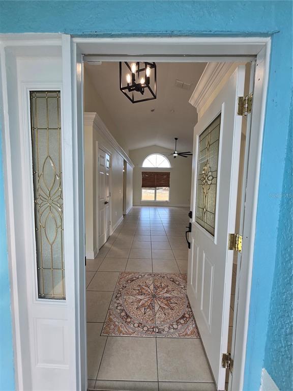 An open front door reveals a tiled entryway with a decorative medallion and interior hallway — 3190 LORI COURT, DELTONA, FL