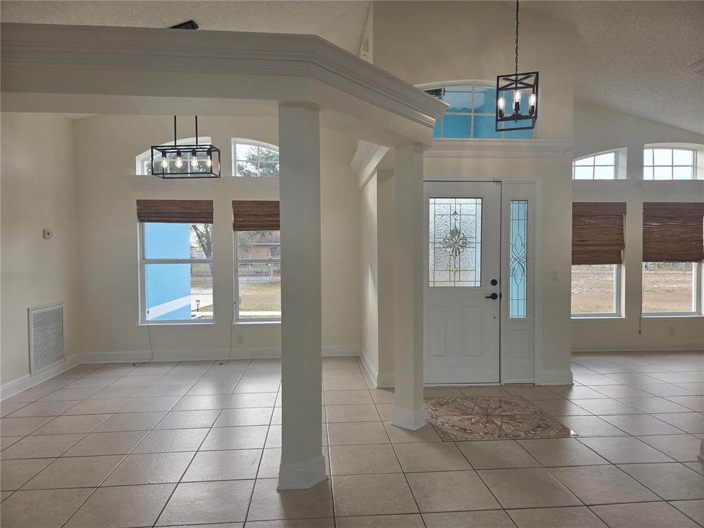 An entryway with tile flooring, white columns, and a front door with a glass insert — 3190 LORI COURT, DELTONA, FL