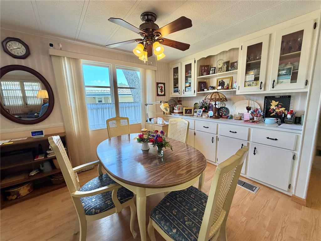A dining room features a wooden table, four chairs, built-in cabinetry, and a ceiling fan — 167 JACARANDA DRIVE, LEESBURG, FL