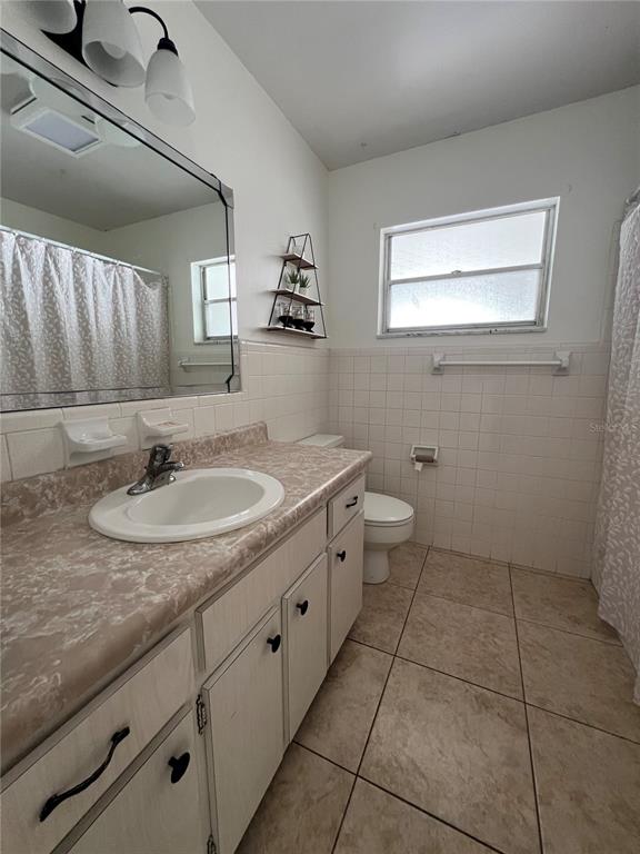 A bathroom features a vanity with a laminate countertop, a mirror, and a tiled shower — 1238 WOODMERE DR, ALTAMONTE SPRINGS, FL