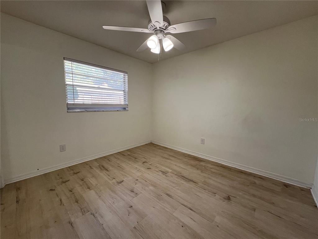 An empty bedroom features light wood-look flooring, white walls, and a ceiling fan — 1238 WOODMERE DR, ALTAMONTE SPRINGS, FL