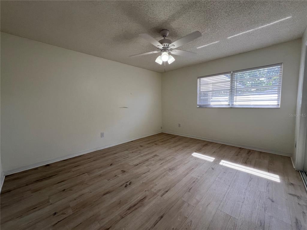 An empty bedroom features light wood-look flooring, white walls, and a ceiling fan — 1238 WOODMERE DR, ALTAMONTE SPRINGS, FL