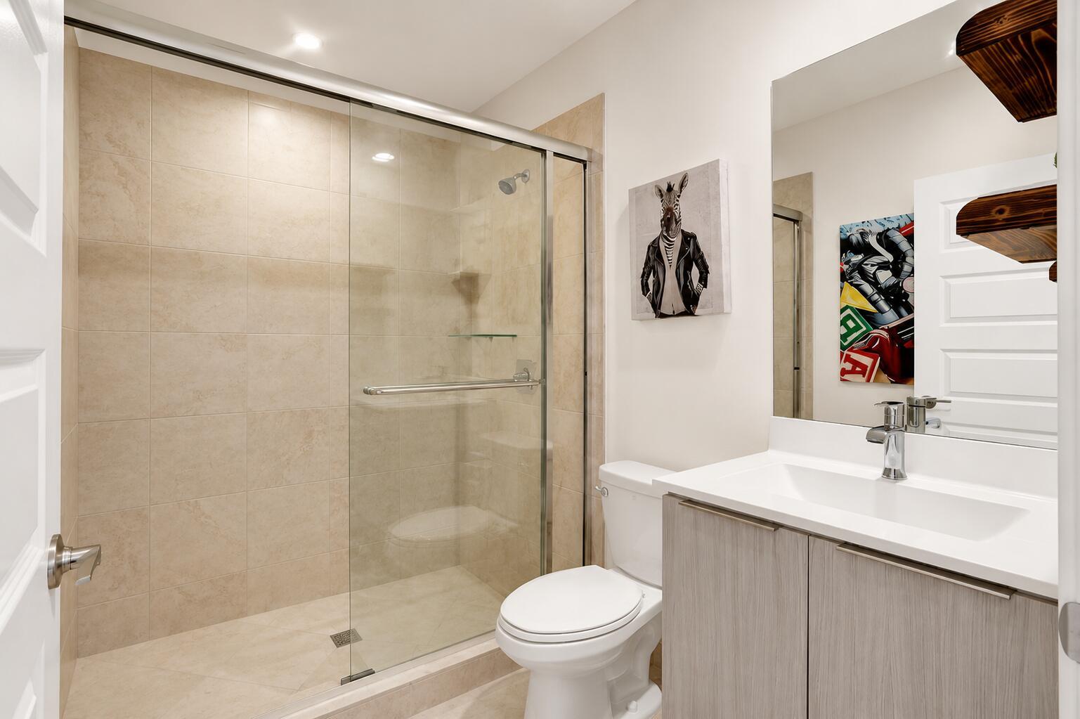 A bathroom featuring a glass-enclosed shower, a white toilet, and a light wood vanity — 4716 NW 84th Court, Doral FL 33166, DORAL, FL