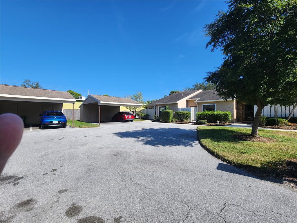 A paved driveway leads to two covered carports and a single-story house with landscaping — 3439 TALLYWOOD LANE UNIT 7139, SARASOTA, FL