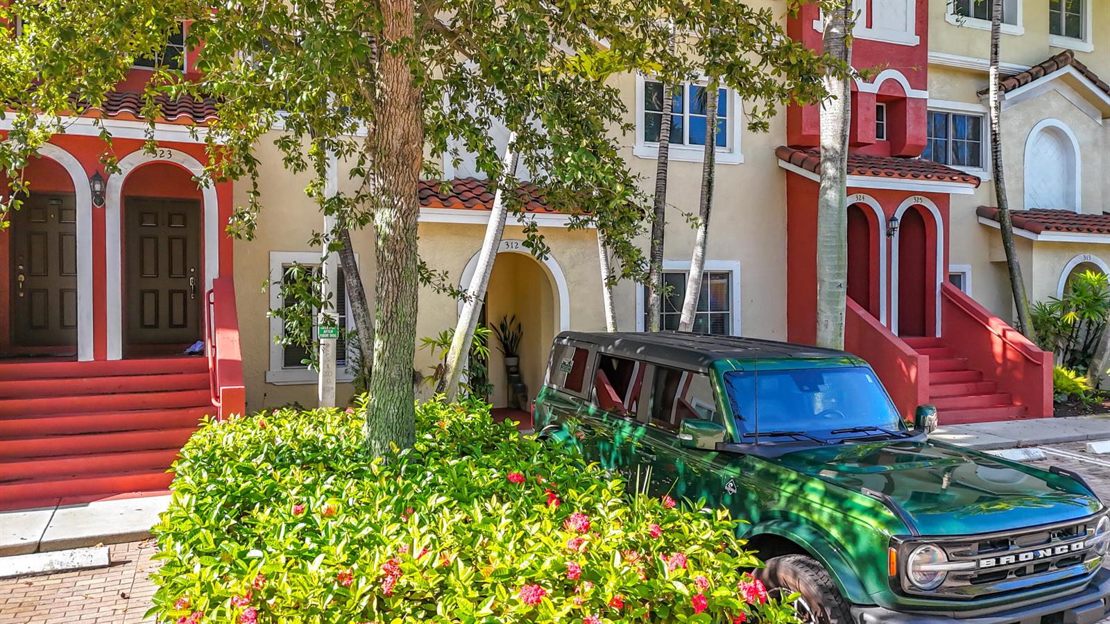 A green Ford Bronco is parked in front of a multi-unit residential building with red accents — 312 Bayfront Drive, Boynton Beach FL 33435, BOYNTON BEACH, FL