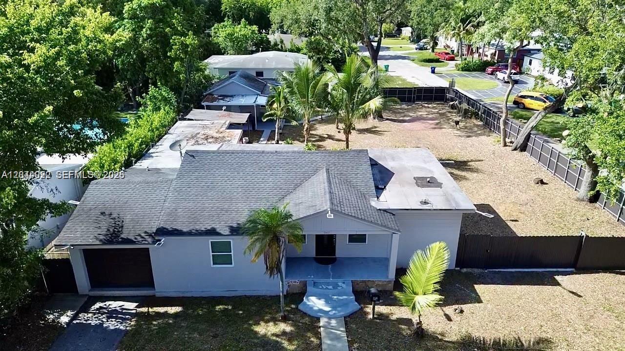 An aerial view shows a single-story house with a gray roof and a fenced yard — 947 NE 149th St, Miami FL 33161, MIAMI, FL