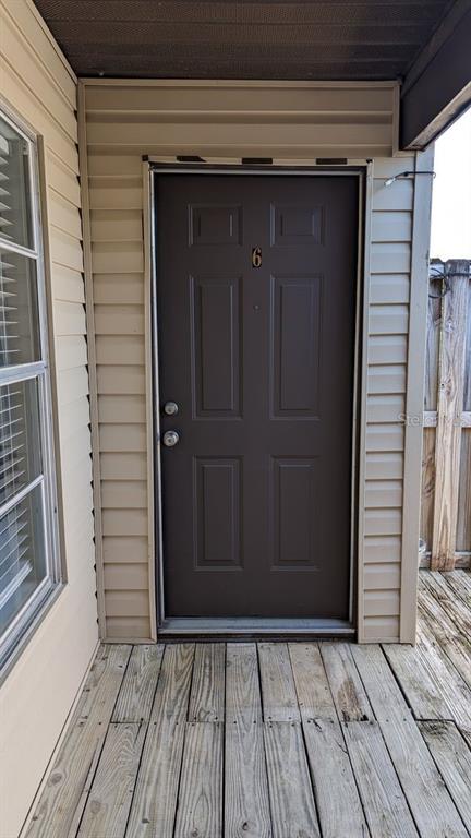 A dark brown front door with the number six sits on a wooden porch — 3924 SW 26TH DRIVE UNIT 6, GAINESVILLE, FL