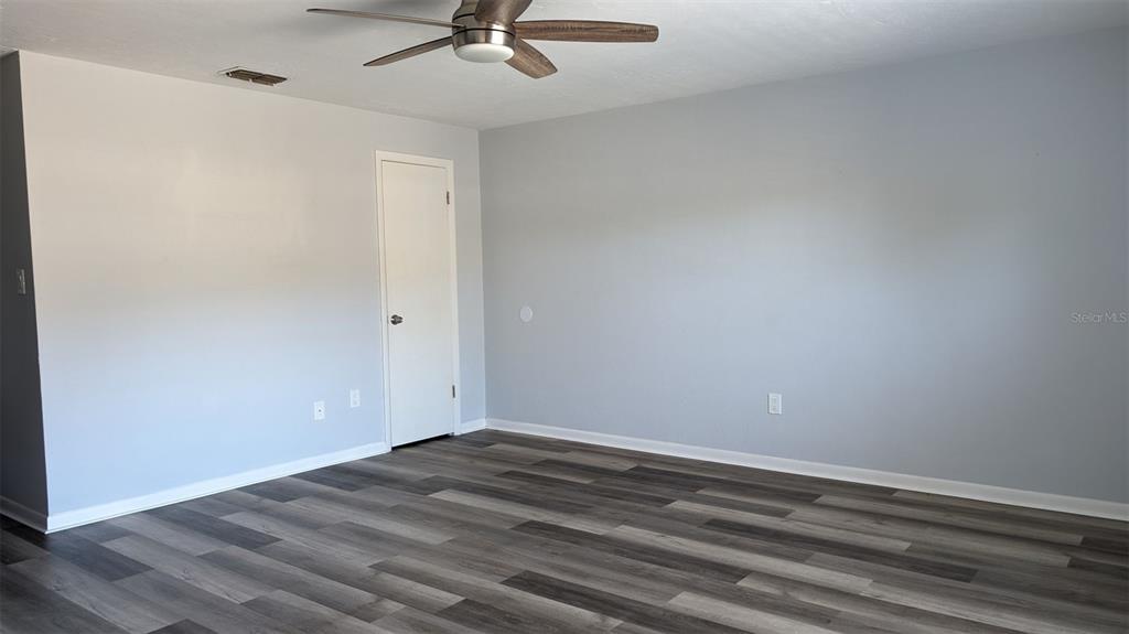 An empty room with light gray walls, wood-look flooring, and a ceiling fan — 3924 SW 26TH DRIVE UNIT 6, GAINESVILLE, FL