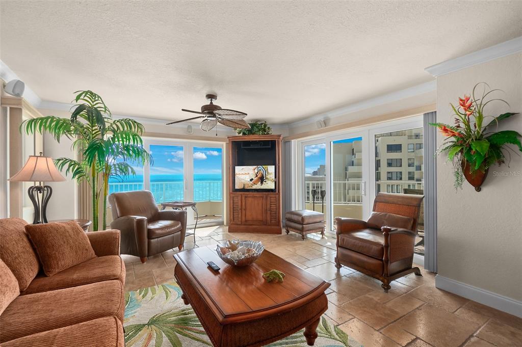 A living room with tile floors, a wooden coffee table, and sliding doors overlooking the ocean — 2937 S ATLANTIC AVENUE UNIT 1907, DAYTONA BEACH SHORES, FL