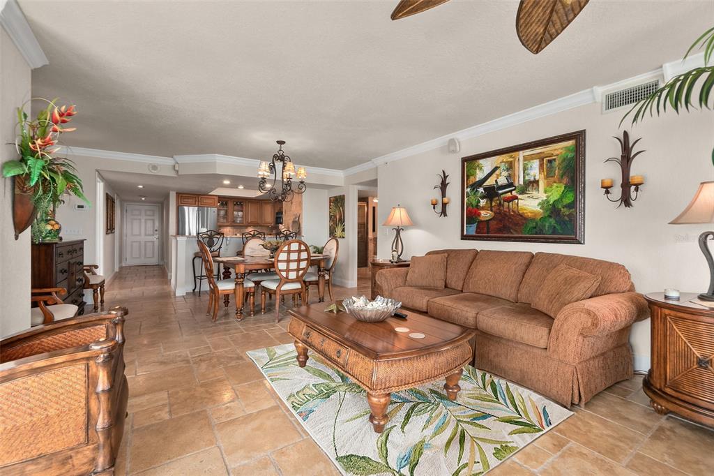 A living room and dining area with tile floors, a brown sofa, and wooden furniture — 2937 S ATLANTIC AVENUE UNIT 1907, DAYTONA BEACH SHORES, FL