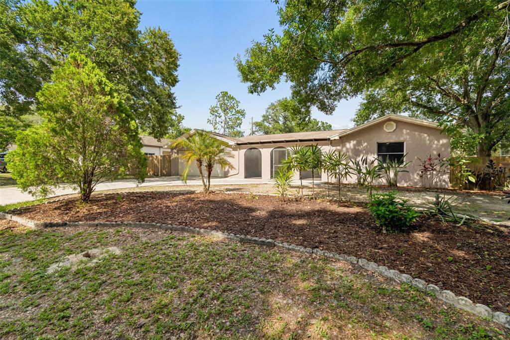 A single-story house with a beige stucco exterior, arched entryways, and a landscaped front yard — 503 ROLLINGVIEW DRIVE, TEMPLE TERRACE, FL
