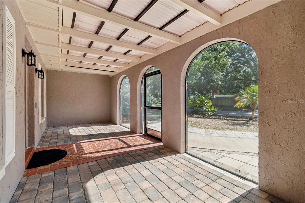 A covered patio features arched screen openings, a paver floor, and a white slatted ceiling — 503 ROLLINGVIEW DRIVE, TEMPLE TERRACE, FL