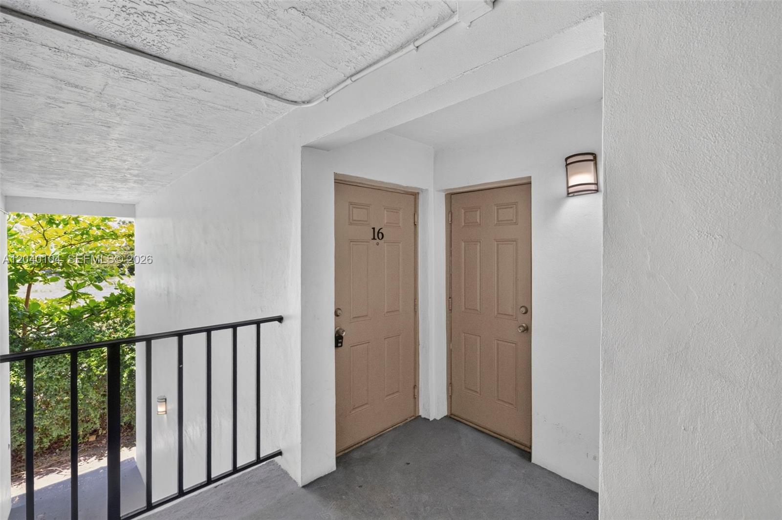 An exterior view shows two tan doors with the number 16 on a concrete walkway — 151 SE 6th Ave # 16, Pompano Beach FL 33060, POMPANO BEACH, FL