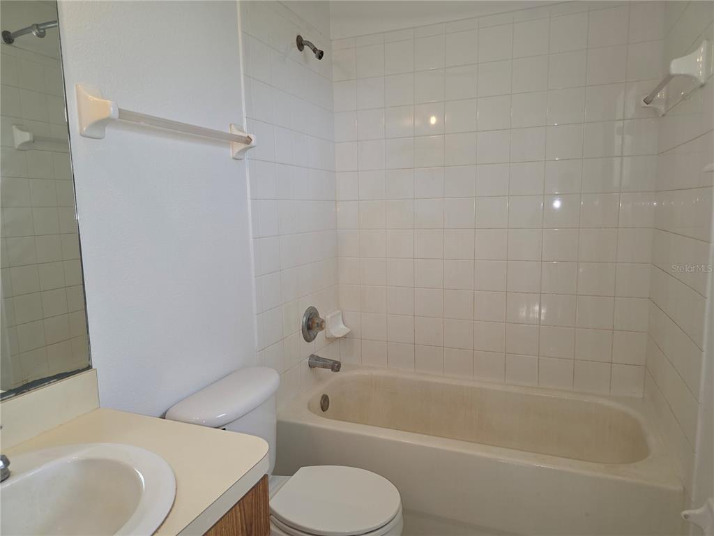 A bathroom features a white vanity, a toilet, and a tiled shower-tub combination — 2017 N 61ST STREET, TAMPA, FL