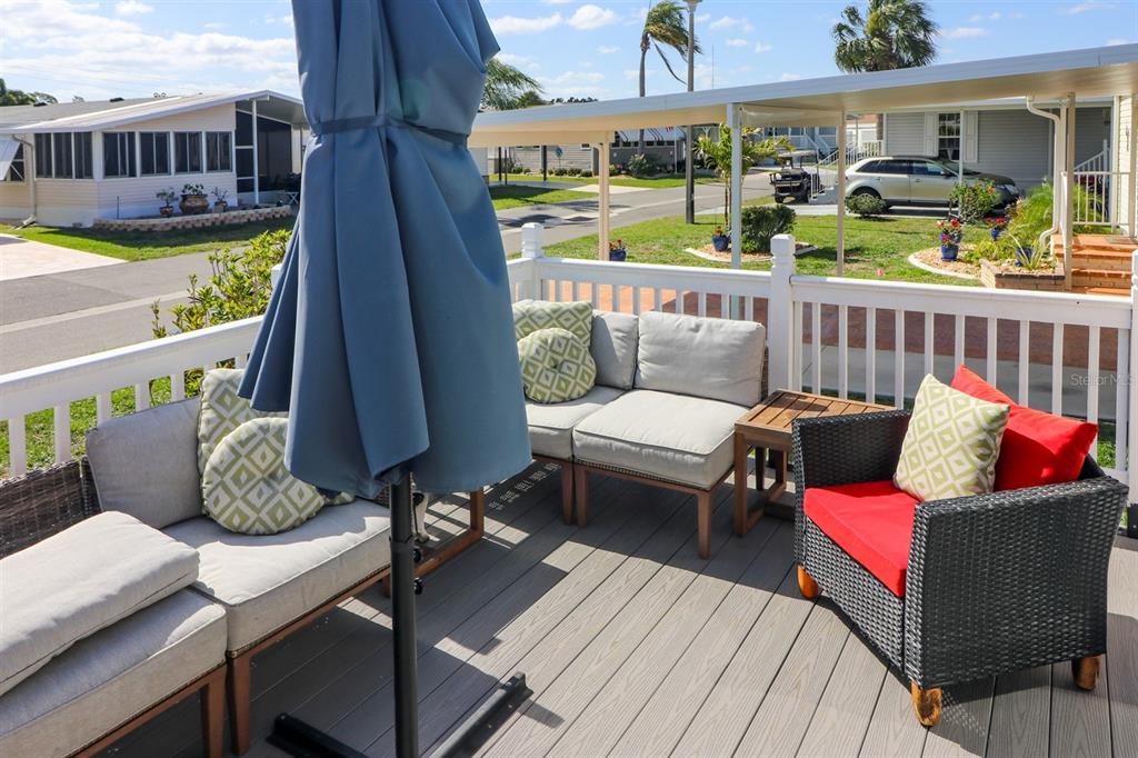 A patio deck features outdoor furniture, a closed umbrella, and a white railing — 2100 KINGS HIGHWAY UNIT 662, PORT CHARLOTTE, FL