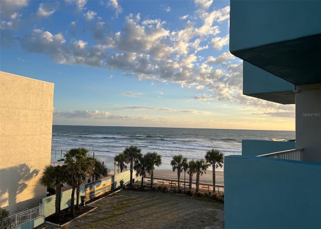 An elevated view of a beach and ocean from a balcony with palm trees — 313 S ATLANTIC AVENUE UNIT 4100, DAYTONA BEACH, FL