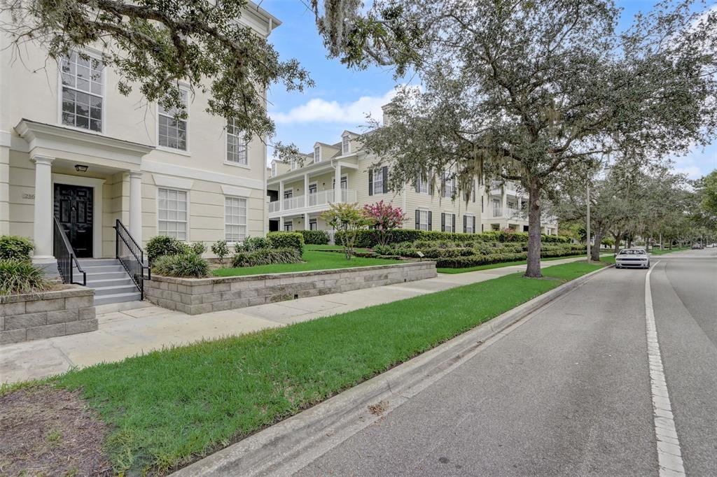 A multi-story residential building with a black front door and a sidewalk along the street — 236 CELEBRATION BOULEVARD UNIT 236, CELEBRATION, FL
