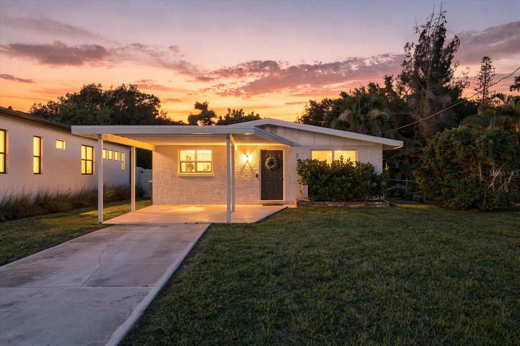 A single-story house with a carport and a concrete driveway at sunset — 2449 WOOD STREET, SARASOTA, FL