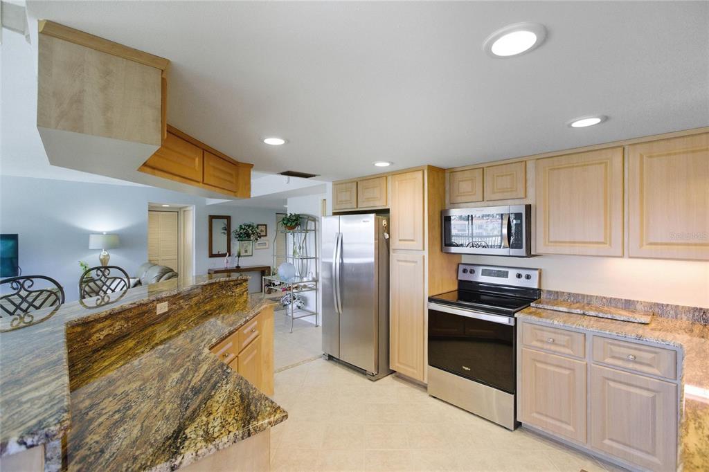 A kitchen features light wood cabinets, granite countertops, and stainless steel appliances — 3255 SUGARLOAF KEY ROAD UNIT 31C, PUNTA GORDA, FL