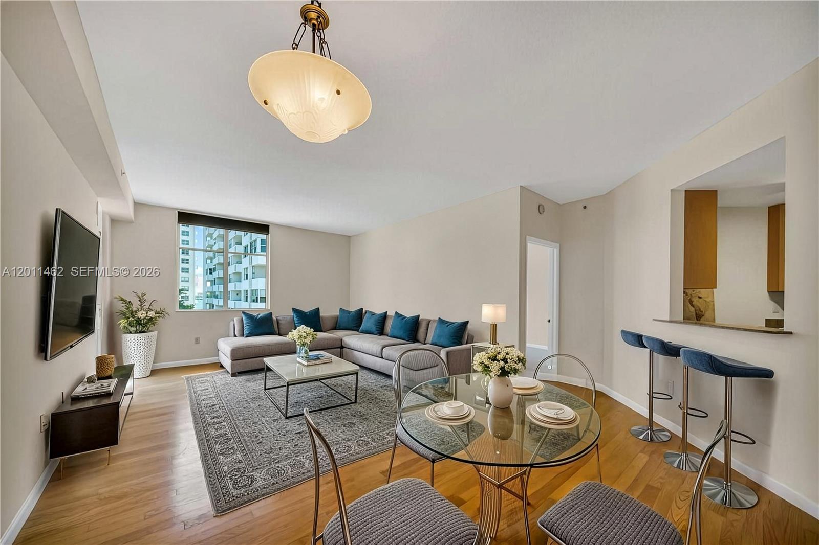 A living and dining area features a sectional sofa, glass table, and breakfast bar — 1 Century Ln # 603, Miami Beach FL 33139, MIAMI BEACH, FL