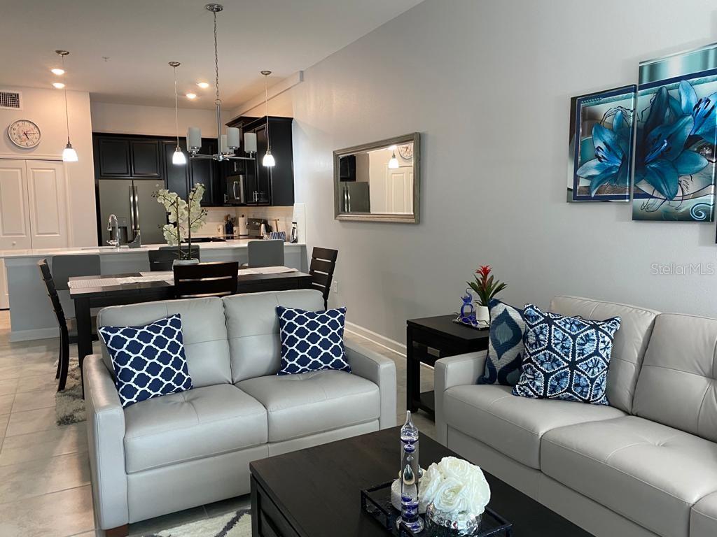 A living room with light gray sofas, a dark coffee table, and an open kitchen — 637 OCEAN COURSE AVENUE, DAVENPORT, FL