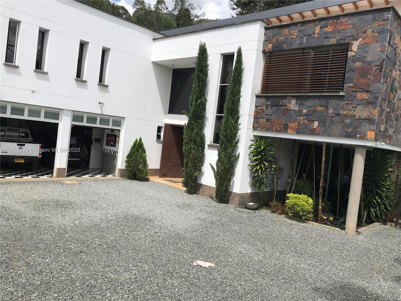A modern two-story house with a gravel driveway, garage, and stone-accented exterior wall — CRA 24 - 36DSUR151 S EL Escobero, AN 055421, AN