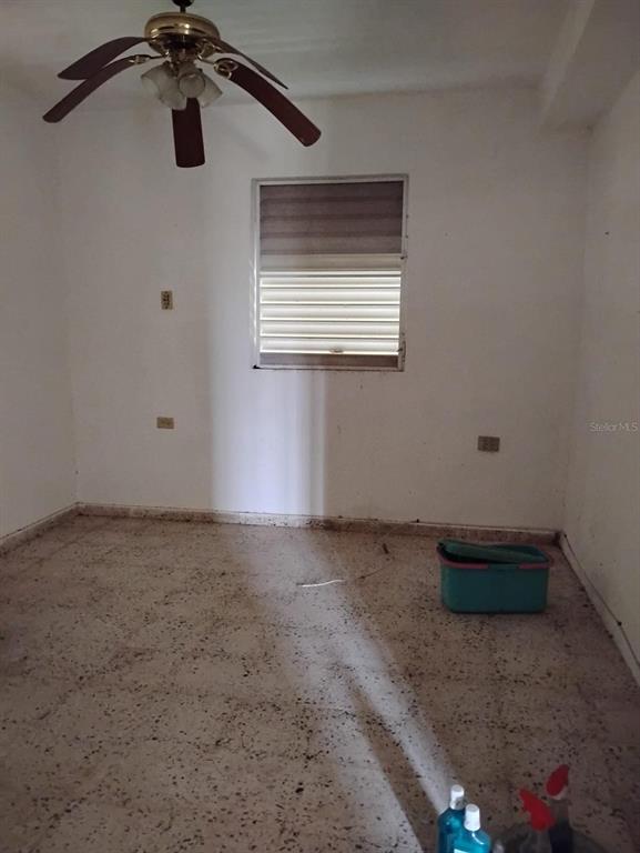 An empty room features white walls, a ceiling fan, a window, and speckled tile flooring — 344 CARR NUEVA BO JAGUITAS, HORMIGUEROS, PR