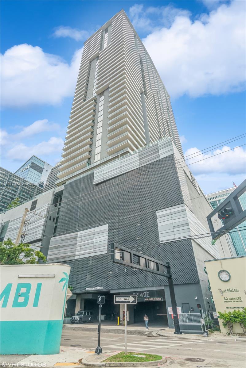 A low-angle view of a tall, modern residential skyscraper with a parking garage base — 88 SW 7th St # 2508, Miami FL 33130, MIAMI, FL
