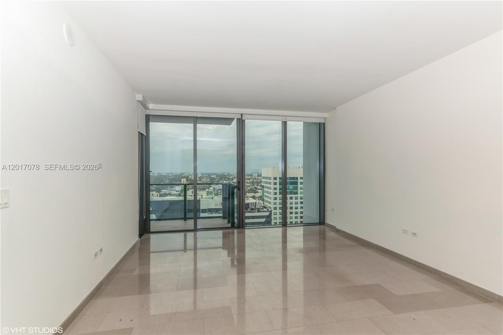 An empty room features polished tile floors, white walls, and floor-to-ceiling glass sliding doors — 88 SW 7th St # 2508, Miami FL 33130, MIAMI, FL