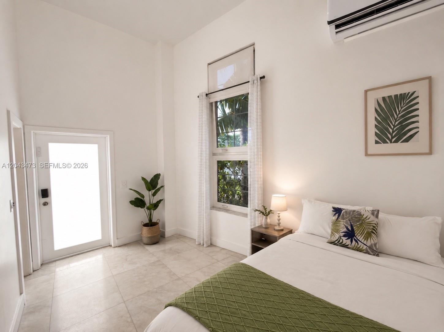 A bedroom features white walls, tile flooring, a window with curtains, and a bed — 3025 Indian Creek Dr # 109, Miami Beach FL 33140, MIAMI BEACH, FL
