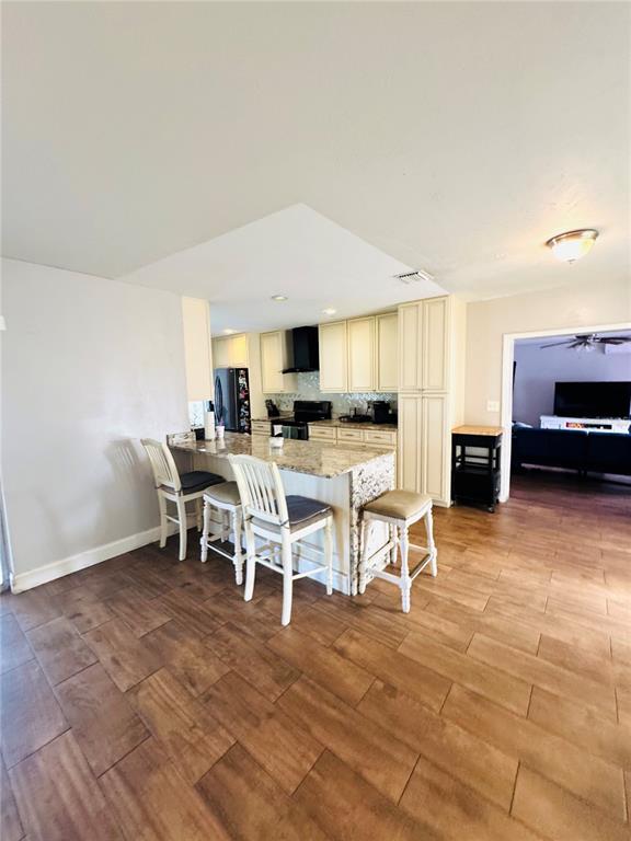 A kitchen with cream cabinets, a granite-topped island, and wood-look tile flooring — 1221 LEEWAY AVENUE, ORLANDO, FL