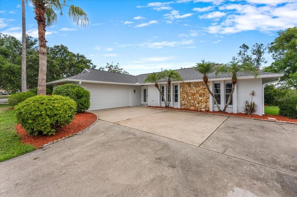 A single-story house with a white exterior, stone facade, and a concrete driveway — 4147 MARINE PARKWAY, NEW PORT RICHEY, FL