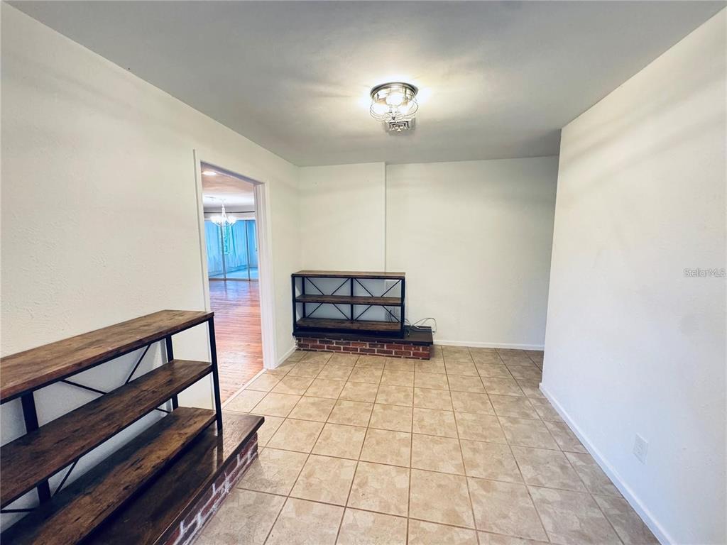 A room with tiled floors, white walls, a ceiling light, and two brick-based wooden shelves — 2022 EDGEWOOD ROAD, LEESBURG, FL