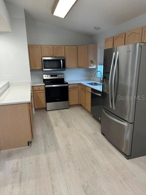 A kitchen features light wood cabinets, stainless steel appliances, and light-colored wood-look flooring — 1525 CHALLENGER AVENUE, DAVENPORT, FL