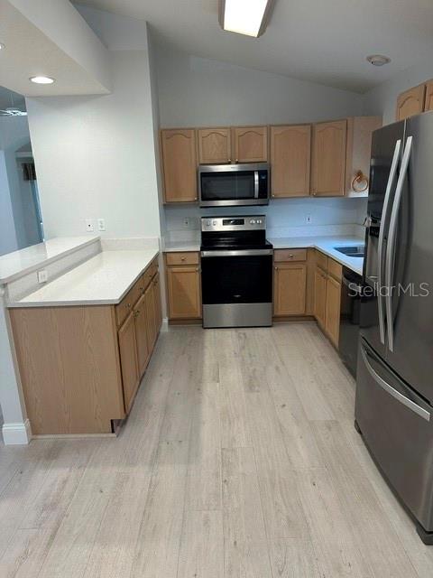 A kitchen features light wood cabinets, stainless steel appliances, and light-colored wood-look flooring — 1525 CHALLENGER AVENUE, DAVENPORT, FL