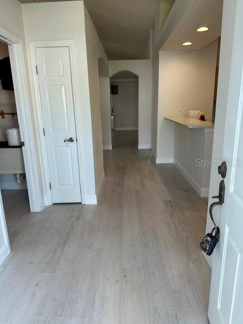 A view from an entryway looking down a hallway toward a kitchen with a breakfast bar — 1525 CHALLENGER AVENUE, DAVENPORT, FL