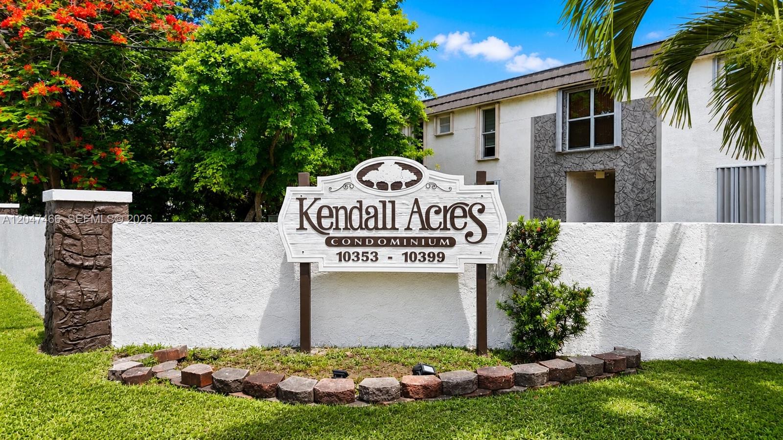 A sign for Kendall Acres Condominium stands in front of a white building and trees — 10381 N Kendall Dr # M8, Miami FL 33176, MIAMI, FL