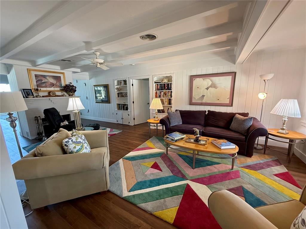 A living room features a colorful geometric rug, a purple sofa, and white paneled walls — 3534 CASEY KEY ROAD, NOKOMIS, FL
